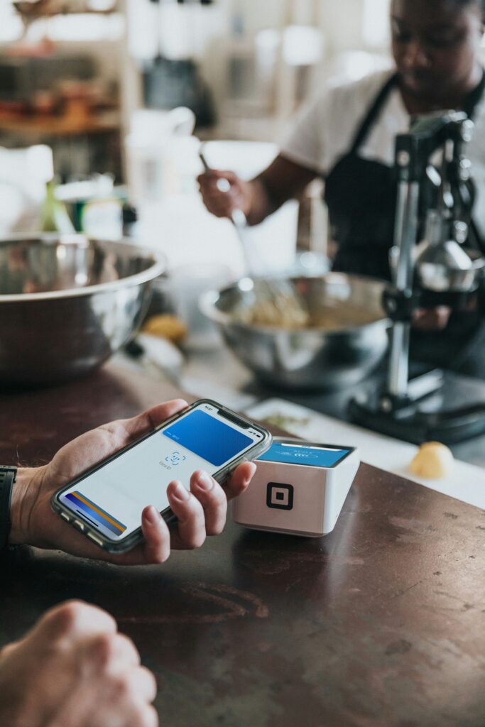 Un barbat care urmeaza sa polateasca cu Apple Pay nota de plata de la un restaurant